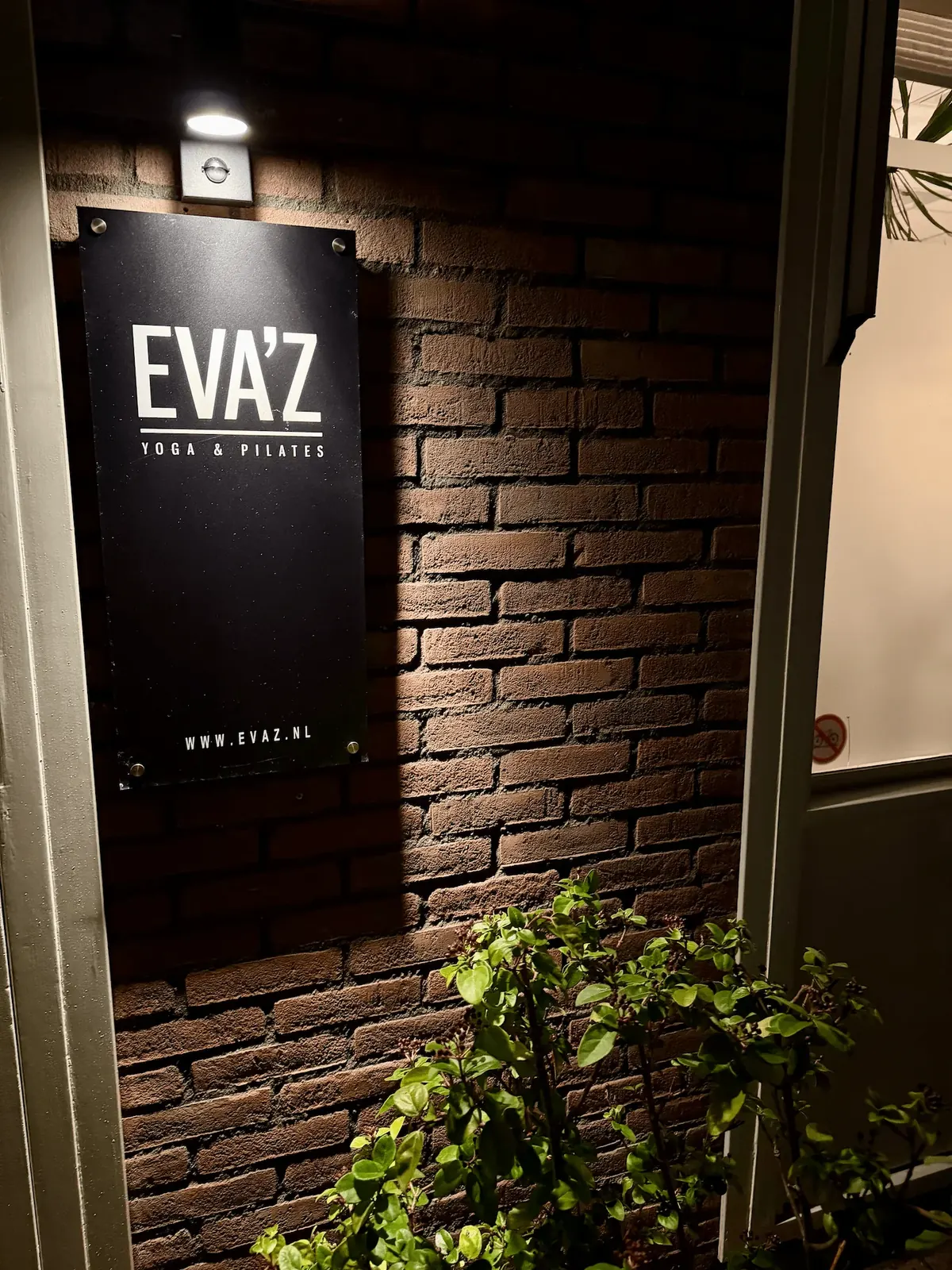 Verlichte entree van EVA’Z in de avond