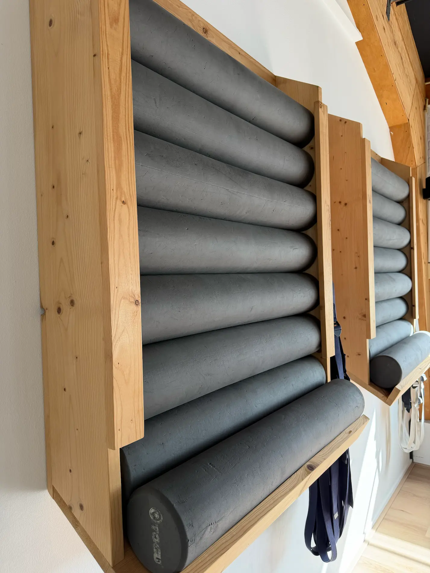 Grijze yoga bolsters en rollen in de studio van EVA’Z